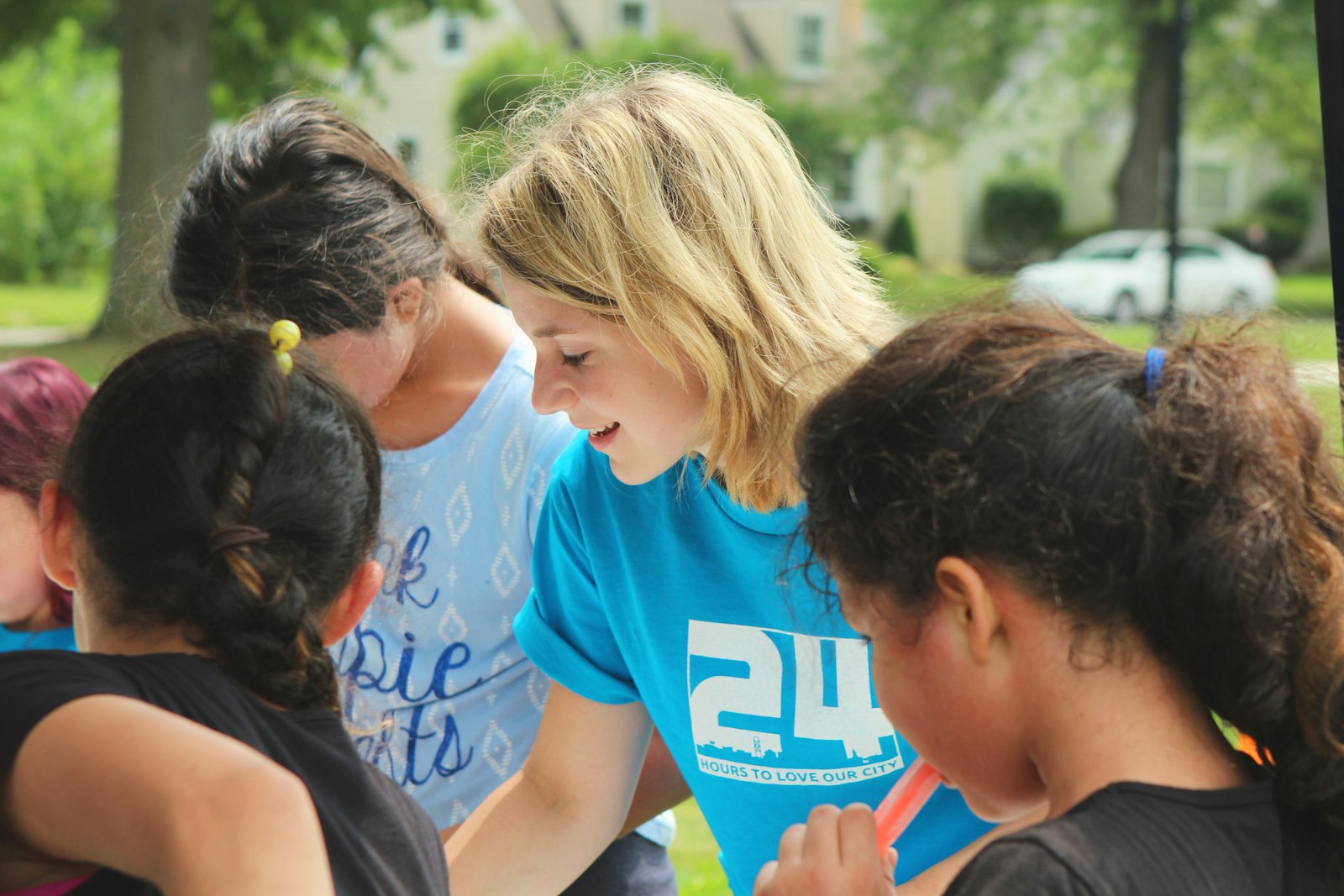 A group of teen volunteers huddled together outdoors, planning their next community activity